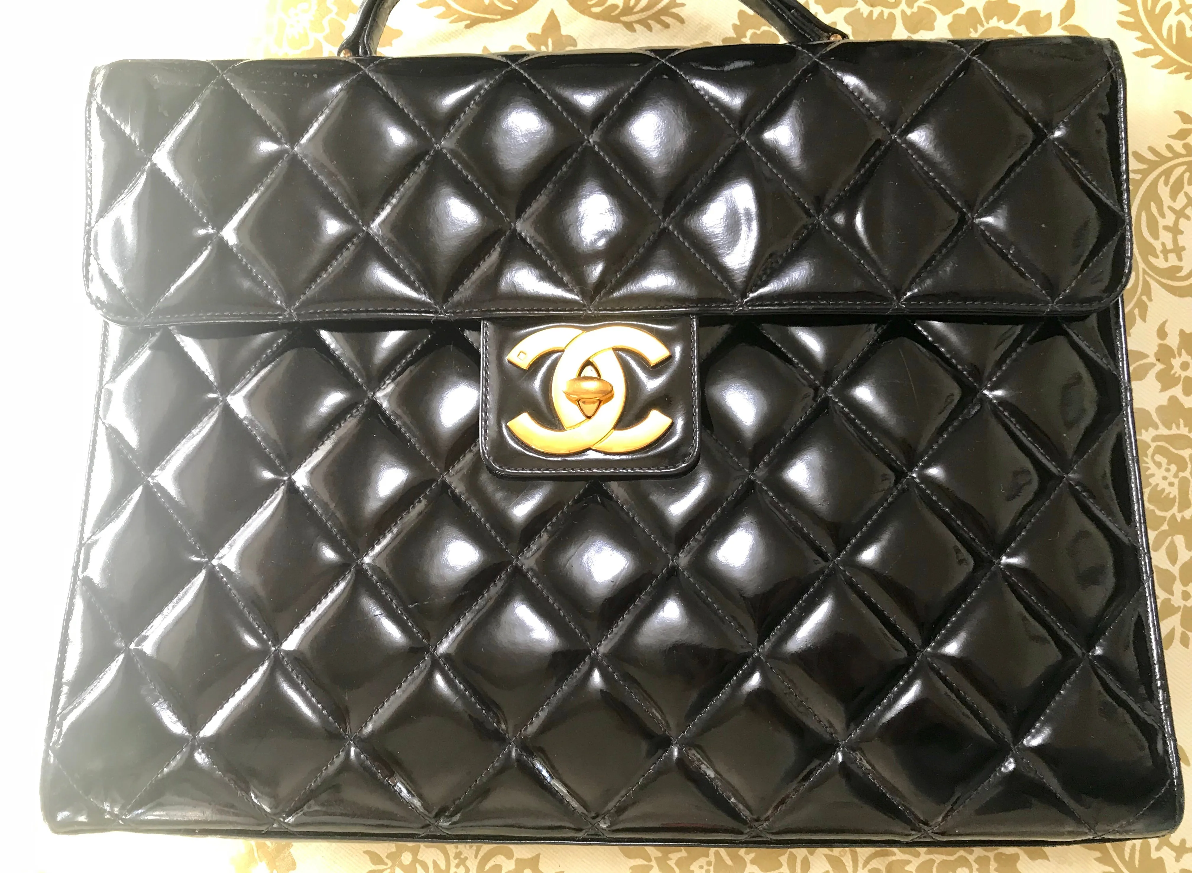 1990s. Vintage CHANEL black patent enamel briefcase business bag with golden large CC motif. Classic and traditional masterpiece you must have.