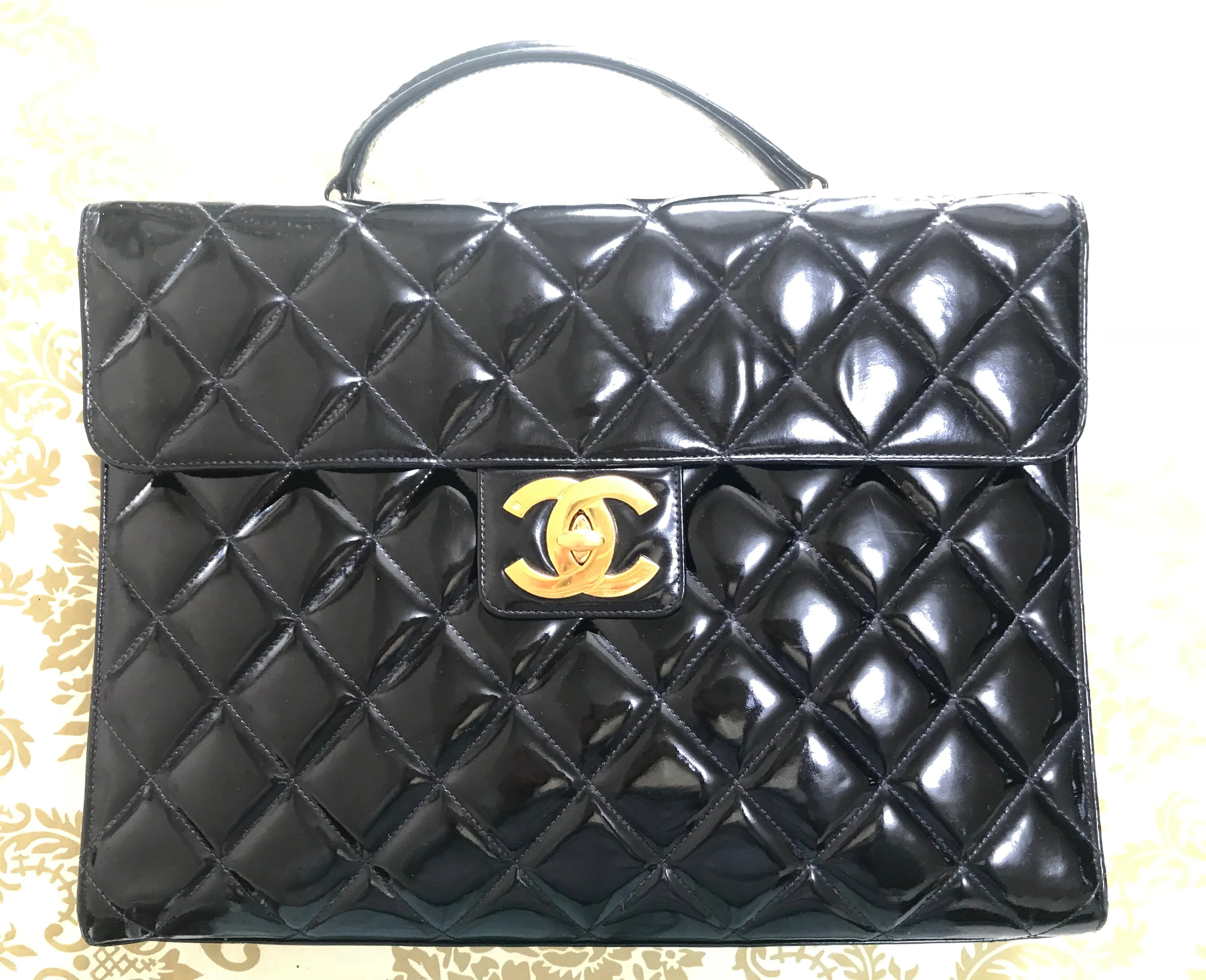 1990s. Vintage CHANEL black patent enamel briefcase business bag with golden large CC motif. Classic and traditional masterpiece you must have.